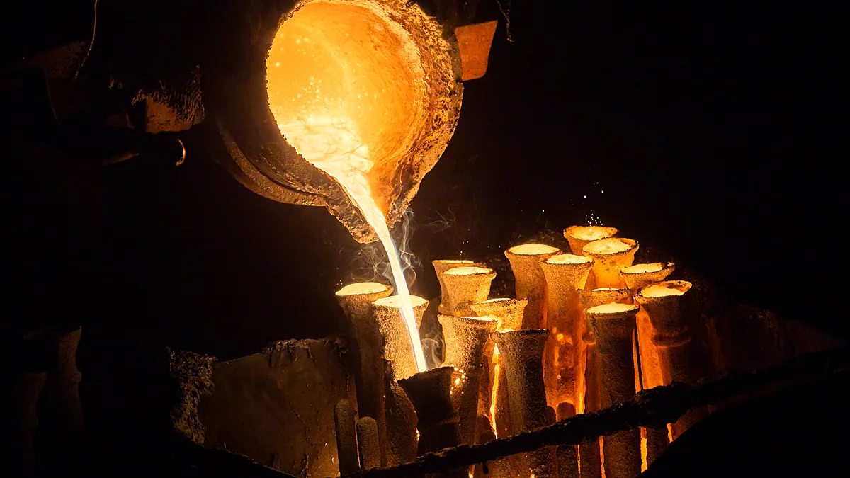 Molten metal being poured from a ladle into casting moulds